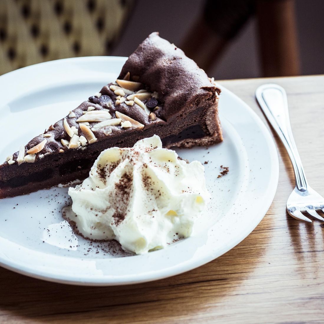 Homemade piece of chocolate cake with whipped cream at Café Klint in Gudhjem harbor.